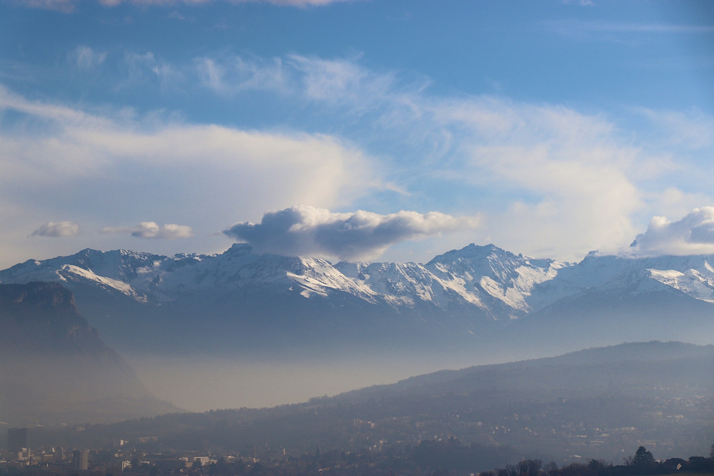 A snow-capped mountain range under a blue sky
