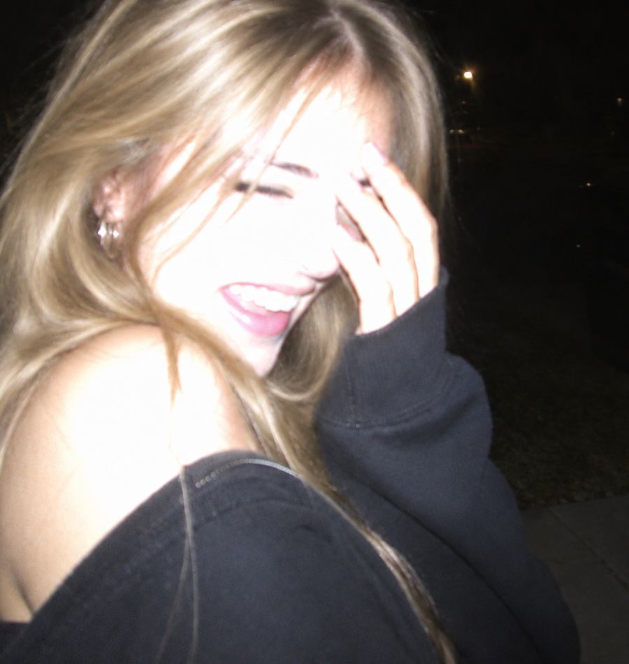A woman laughing, caught with flash