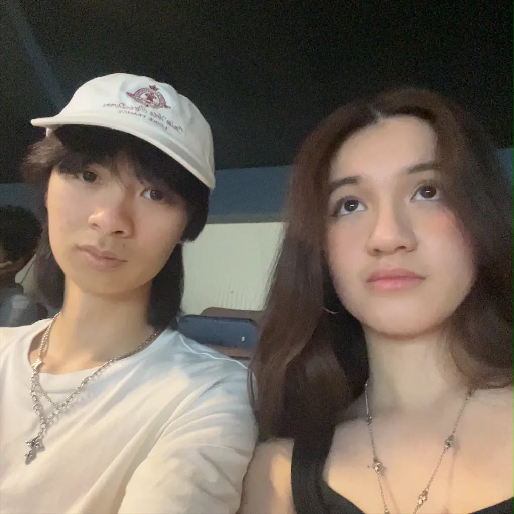 Two people sitting side by side and looking at the camera